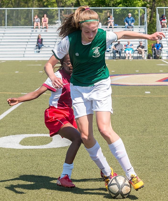 Girl trying to keep ball from other team