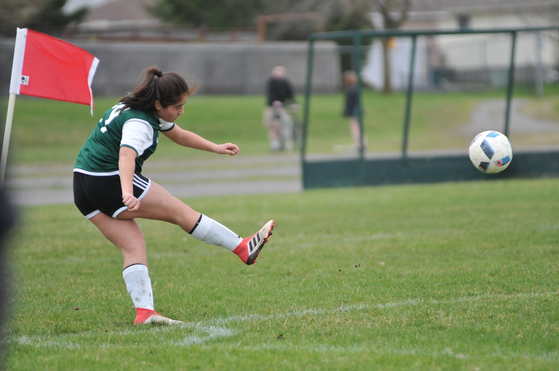 Jr Girl kicking soccor ball.