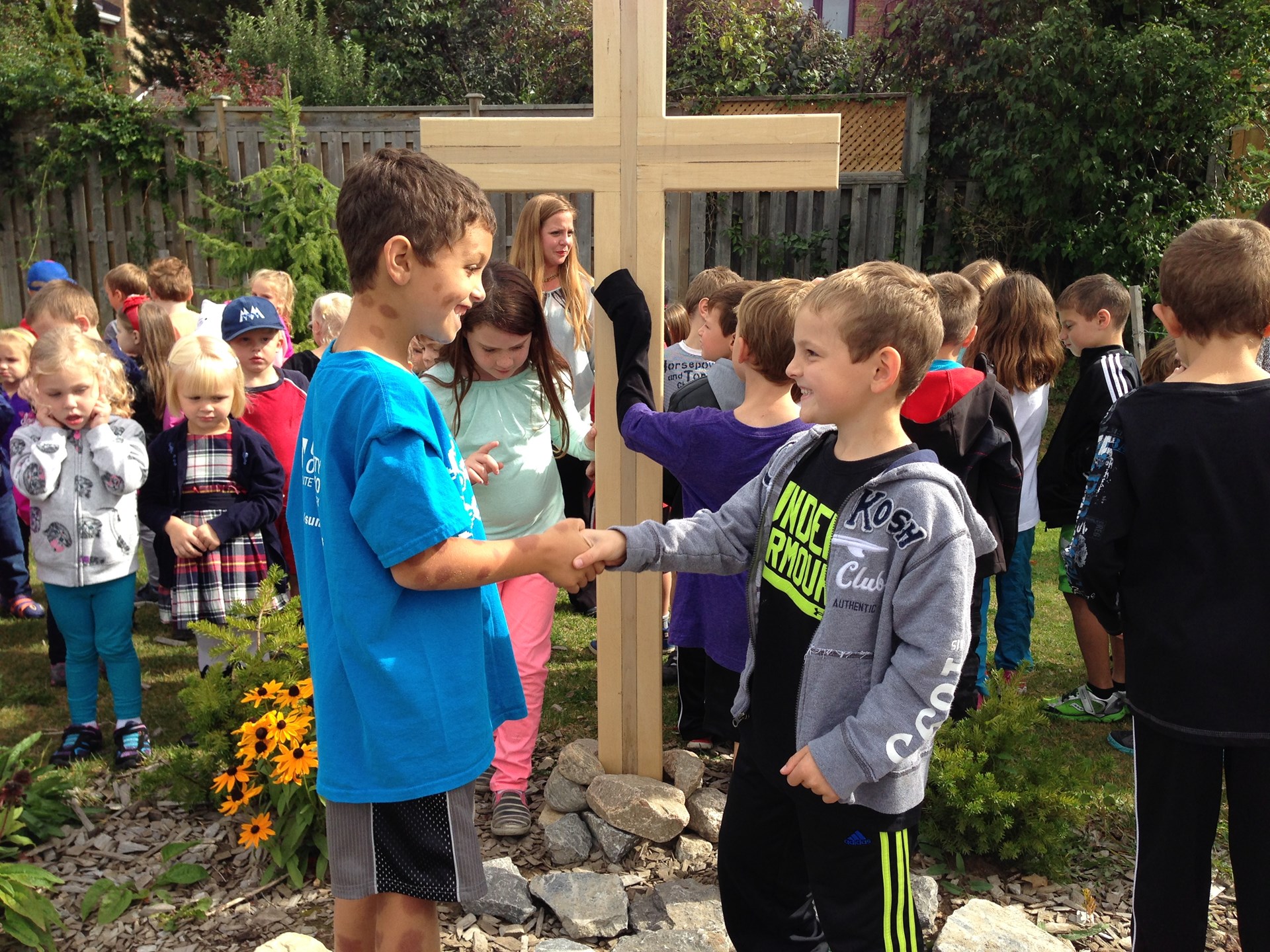 Students outside in front of cross.