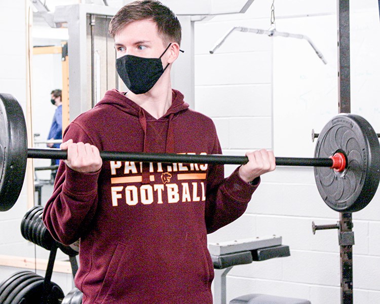 Student lifting barbell.